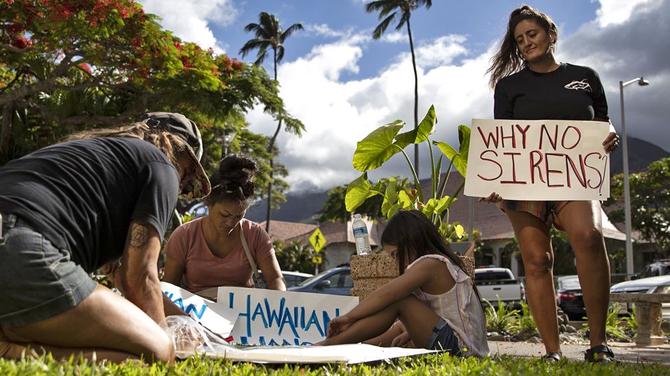 A protester holds a poster reading 'Why no Sirens?' as people demonstrate in front the Maui County Building where officials held a press conference, in Kahului, Hawaii, USA, 14 August 2023