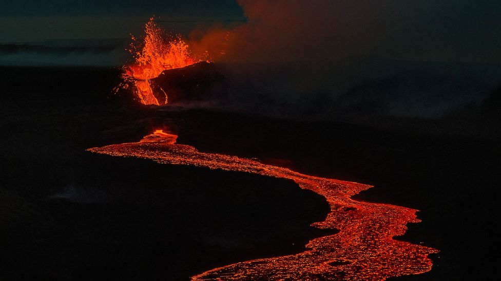 Red hot lava flow with the Litli-Hrútur crater erupting behind